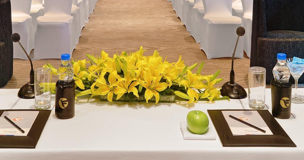 Welcomhotel By Itc Hotels, Richmond Road, Bengaluru Kültér fotó A table with a microphone, a bottle of water, a green apple and a flower arrangement